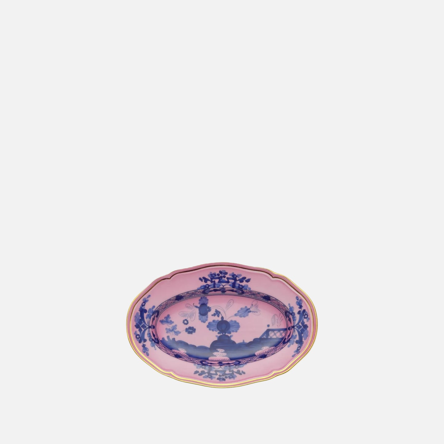 An oval ceramic serving platter with a pink glaze, decorated with blue floral and landscape motifs, and finished with a gold scalloped rim, shown on a plain white background.