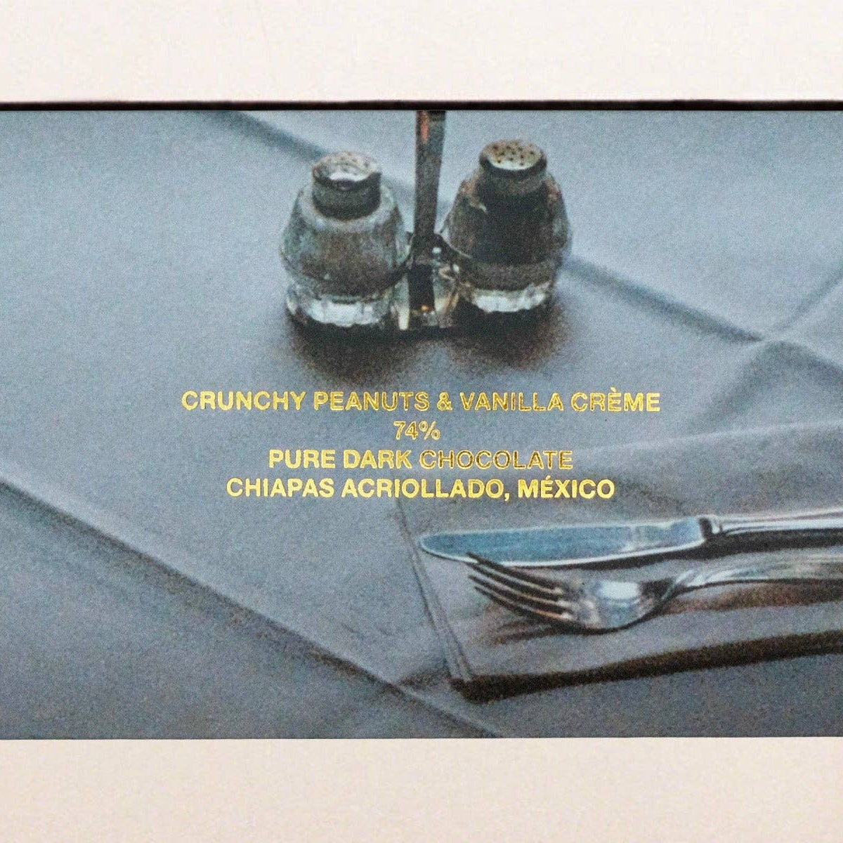 Dining table setting with silverware on a gray cloth, featuring text.
