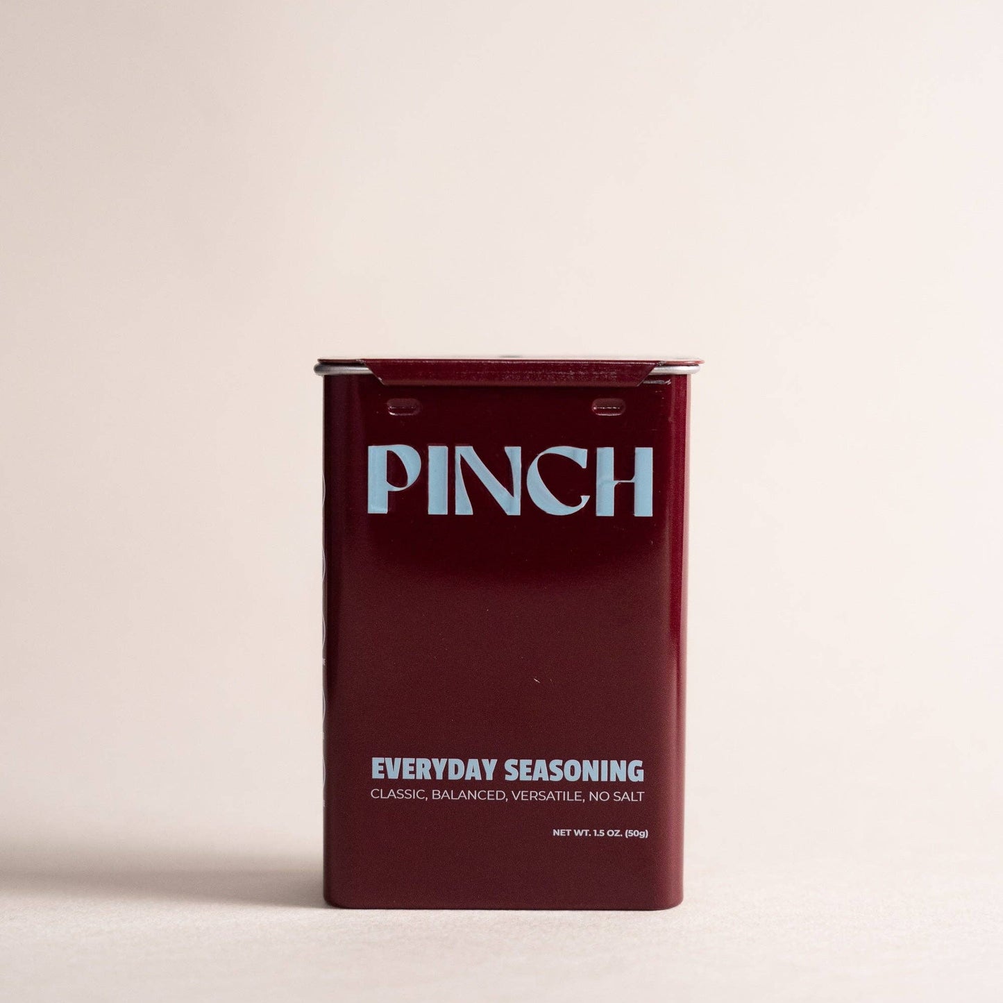 Maroon seasoning packet with 'PINCH' branding on a beige background