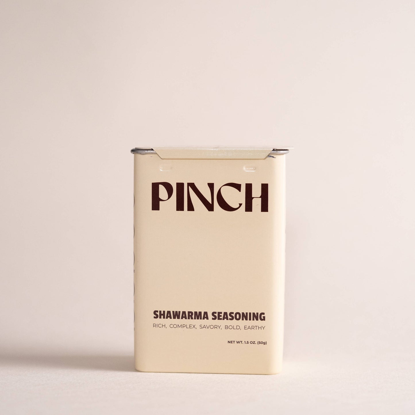 A rectangular cream-colored tin of PINCH Shawarma Seasoning standing upright on a light beige background.