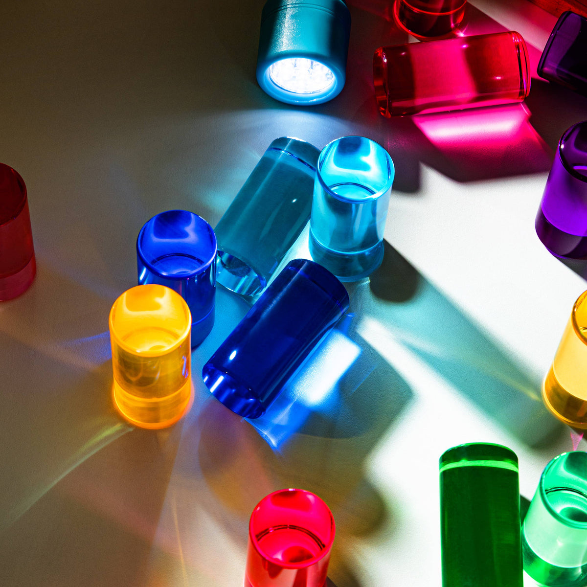 Colorful blocks on a reflective surface with shadows