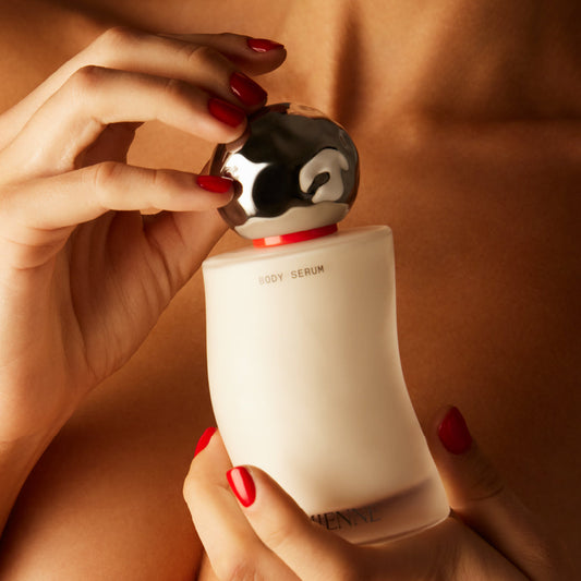 Person holding a skincare bottle with a close-up of the product.