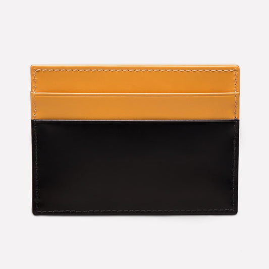 Two-tone black and mustard yellow leather cardholder on a white background