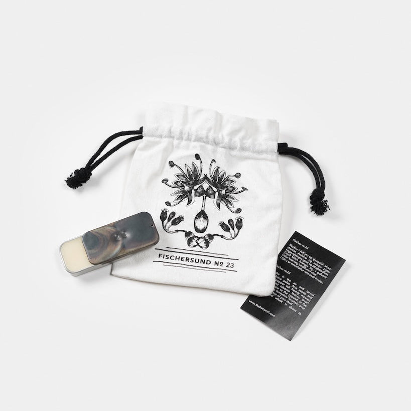 White drawstring bag with black floral design and text, containing a small rectangular item and a card on a white background.