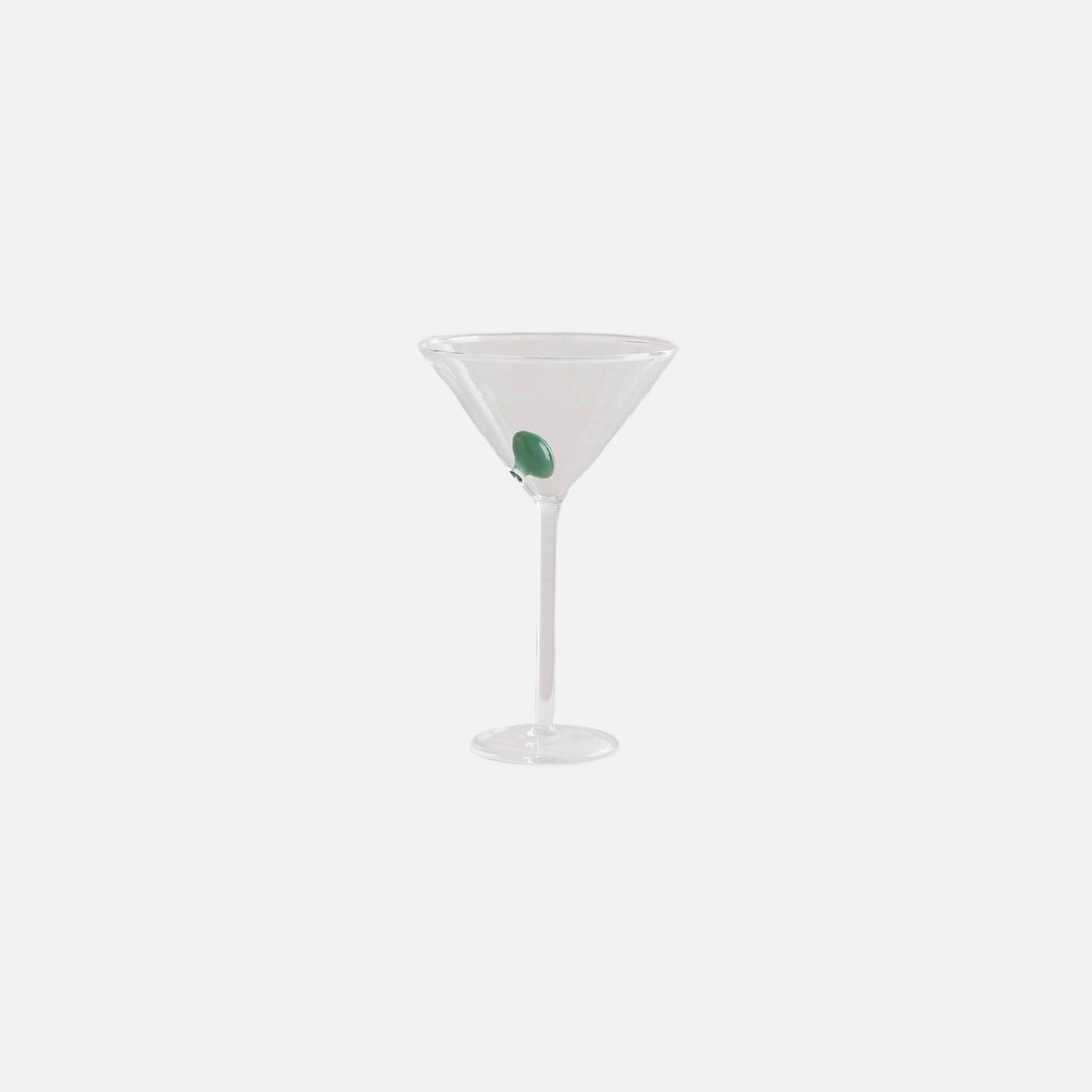 Clear martini glass with a green olive on a white background