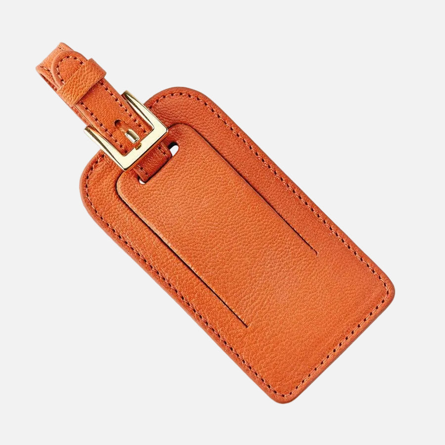 Orange leather luggage tag with a gold buckle on a white background