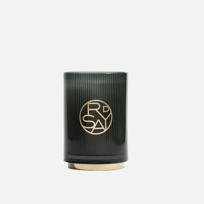 Black cylindrical candle with gold logo on a white background