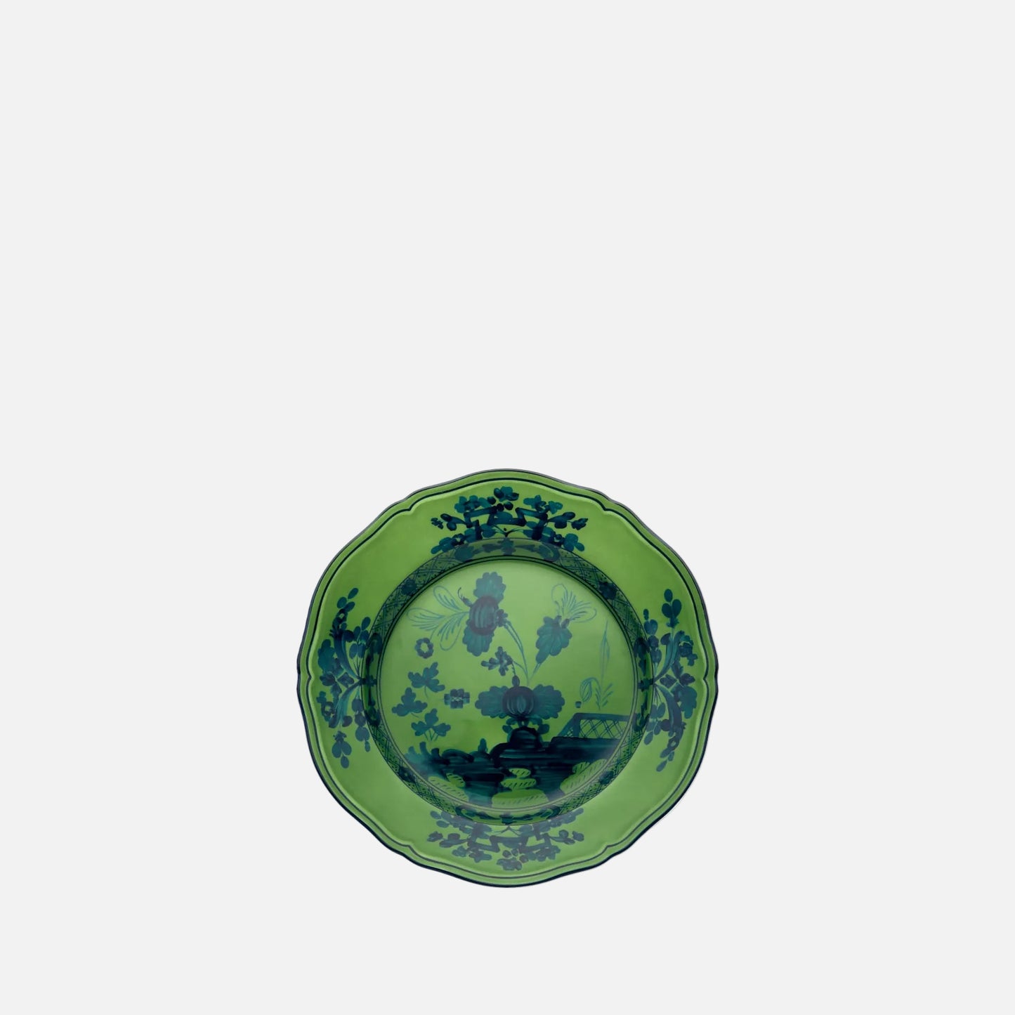 A green ceramic plate with a scalloped rim and a dark blue landscape illustration printed on the inside, shown against a plain white background.