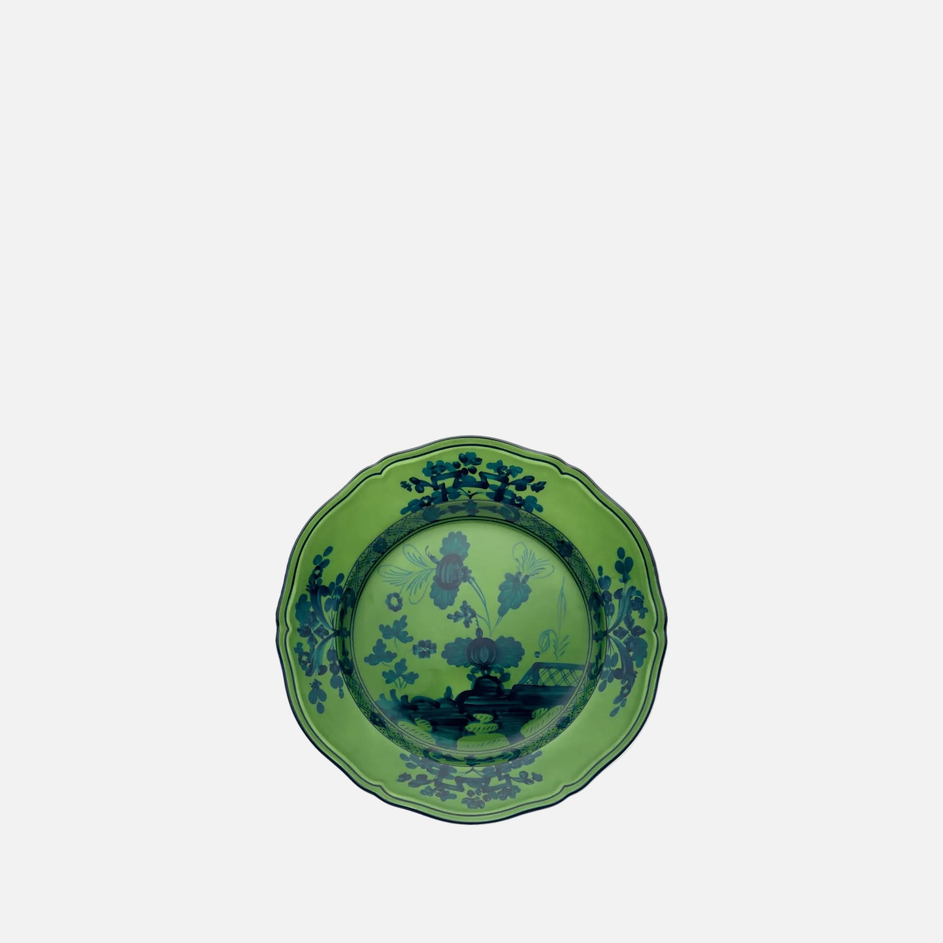 A green ceramic plate with a scalloped rim and a dark blue landscape illustration printed on the inside, shown against a plain white background.