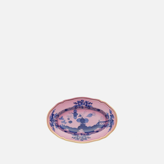 An oval ceramic serving platter with a pink glaze, decorated with blue floral and landscape motifs, and finished with a gold scalloped rim, shown on a plain white background.
