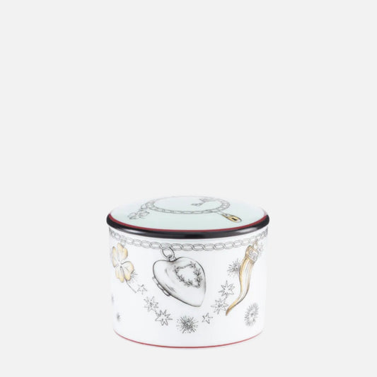 A small cylindrical white ceramic container with a lid, decorated with jewelry-themed illustrations including a heart-shaped locket, a bow and arrow, and silver-toned chain motifs, with thin red and dark blue trim lines.