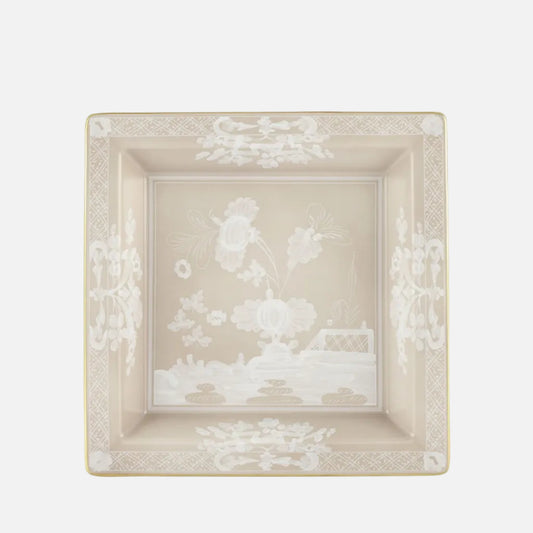A square ceramic dish with a beige and white chinoiserie design, featuring delicate floral and landscape motifs with a gold-toned rim, set against a plain white background.