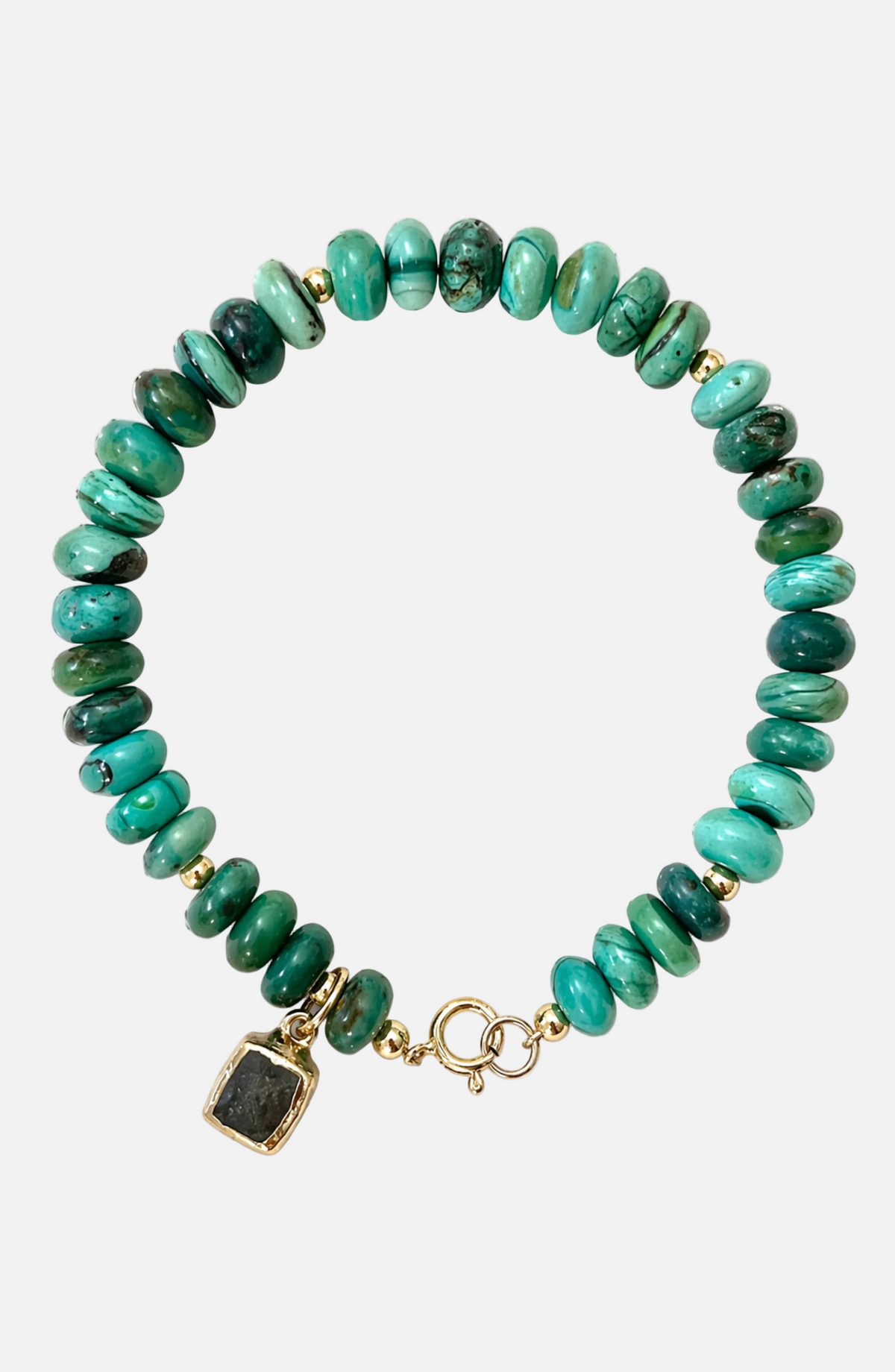 Green beaded bracelet with a gold charm on a white background