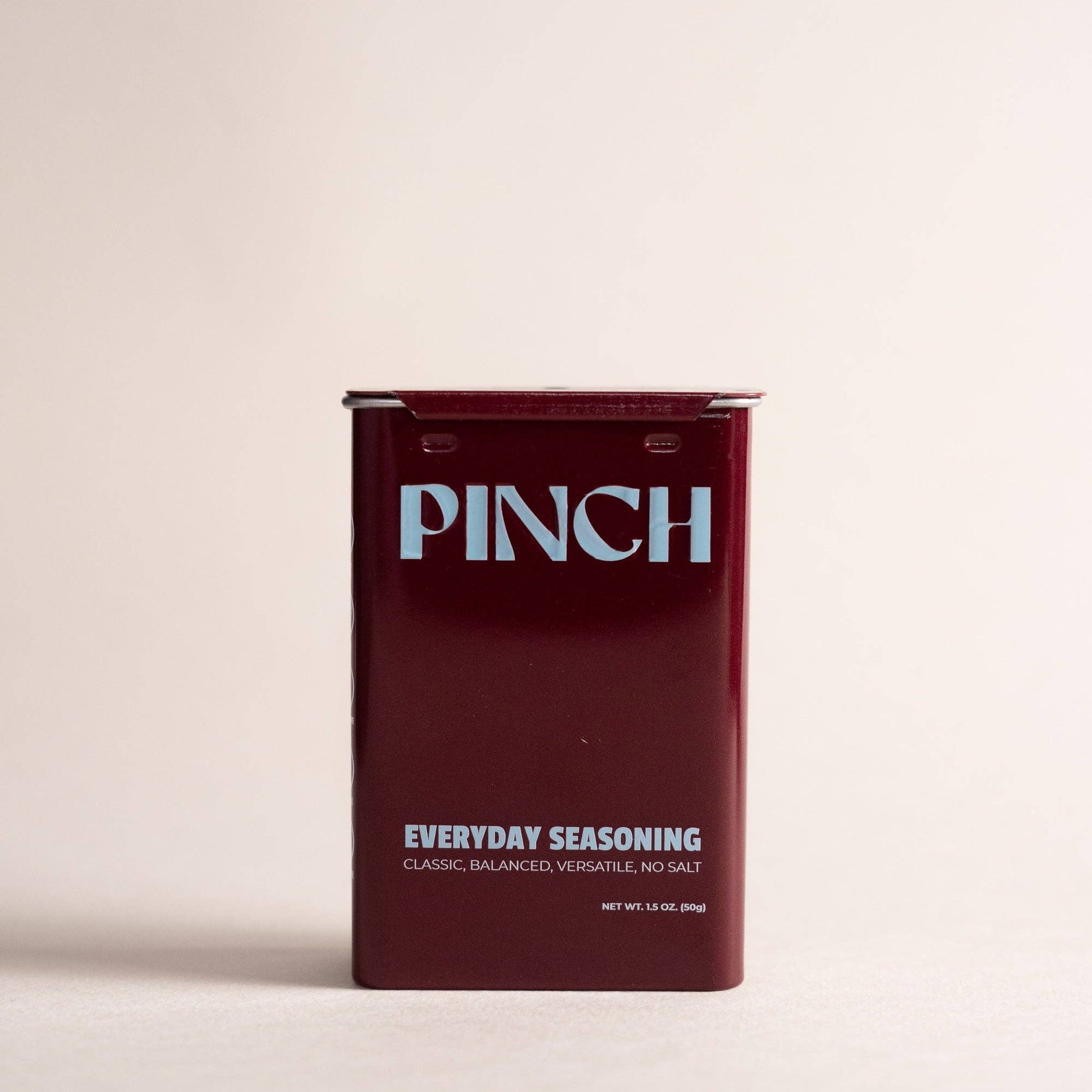 Maroon seasoning packet with 'PINCH' branding on a beige background