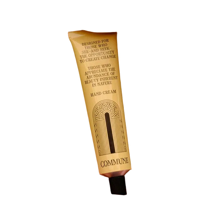 A tube of Commune Hand Cream on a white background.