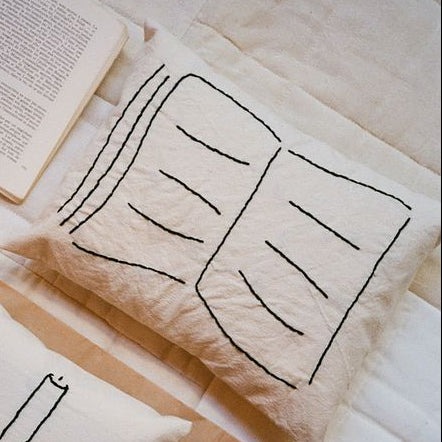 Decorative pillow with book on it