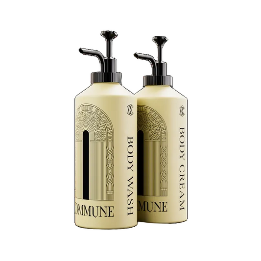 Two cream-colored pump bottles of Commune body wash and body cream with black pumps, shown on a plain white background.