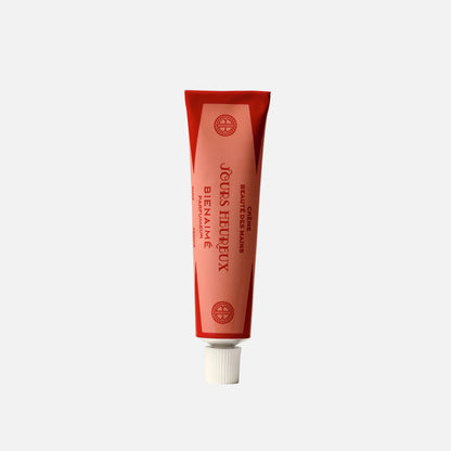 Red tube of 'Jeux Heureux' on a light gray background