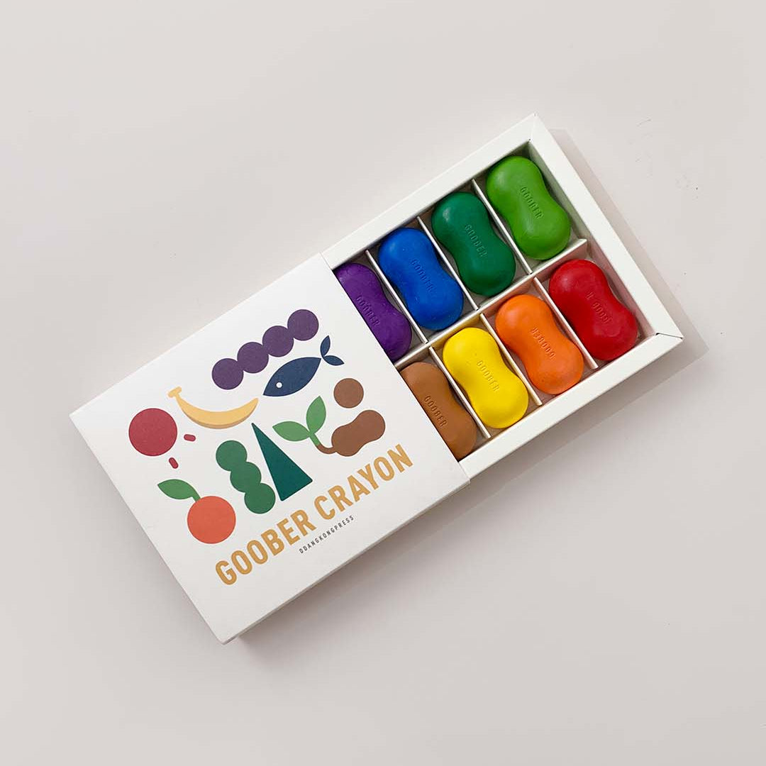 Box of colorful Goobers Crayons on a light gray background