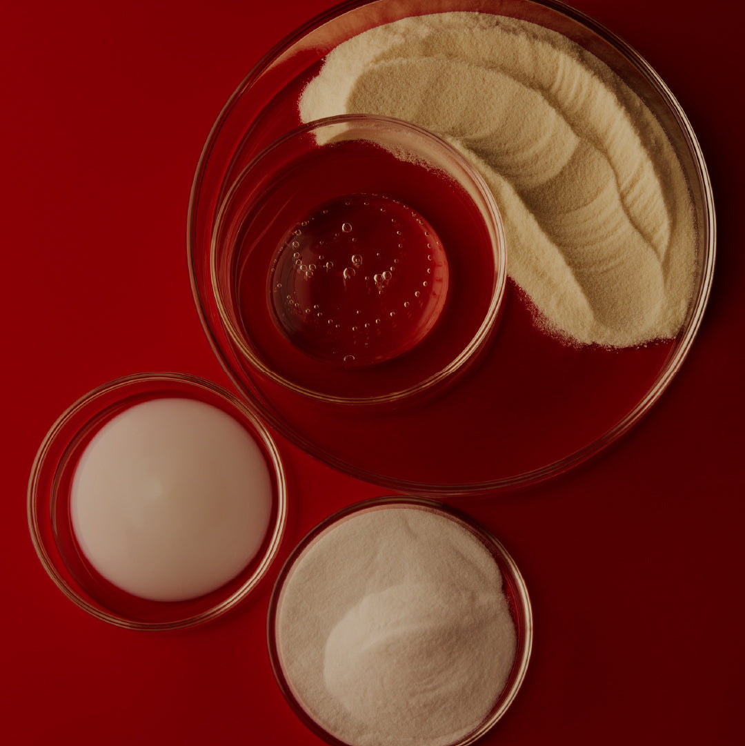 Three small glass containers with white and red substances on a red background
