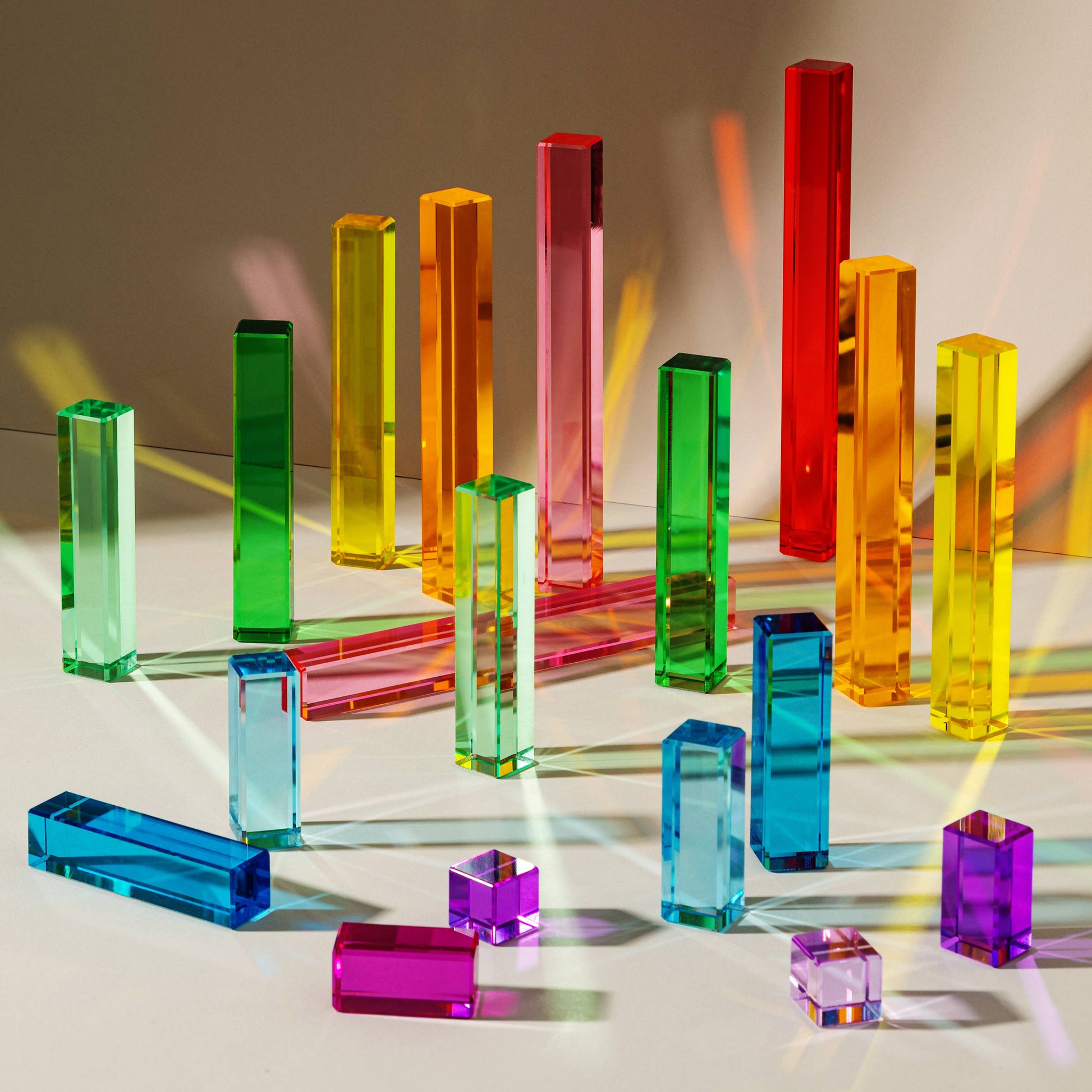 Colorful transparent acrylic blocks on a reflective surface with a gradient background