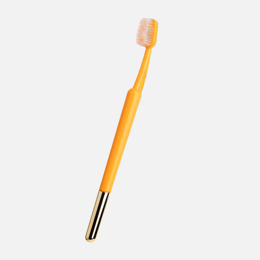 Orange toothbrush with a black handle on a white background