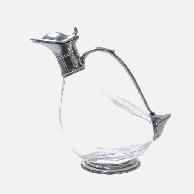 Clear glass decanter with silver metal top and handle on a white background