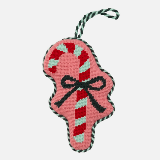 Pink candy cane-shaped toy with a bow and black rope handle on a white background