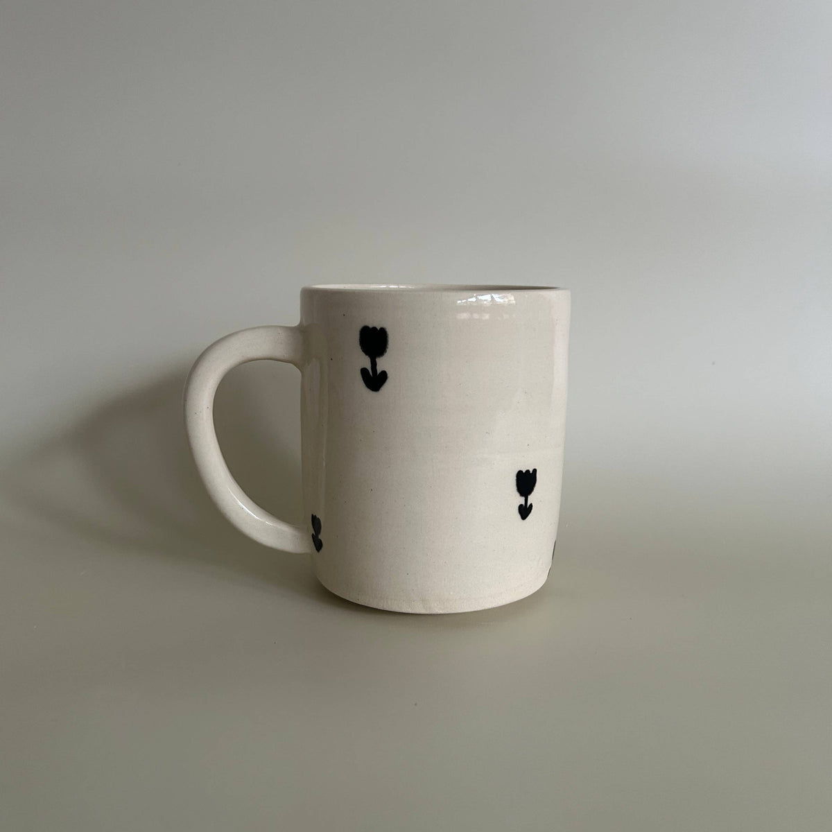 White mug with black heart designs on a gray background
