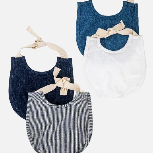 Set of four baby bibs in blue, white, and striped patterns on a white background