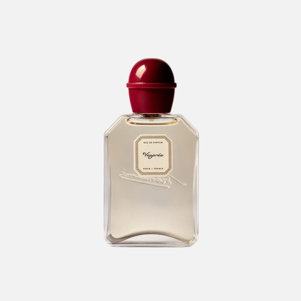 Perfume bottle with a red cap on a light gray background