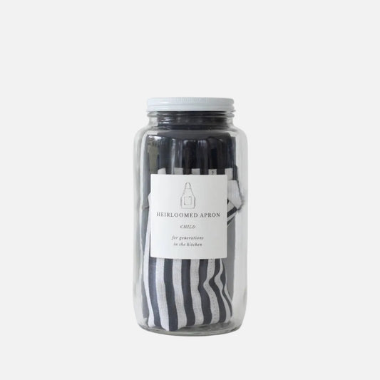 Jar of black and white aprons with a label on a white background
