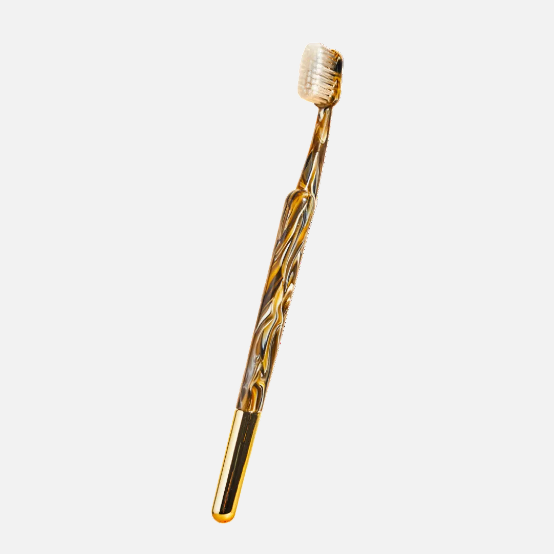 Gold and black toothbrush on a white background