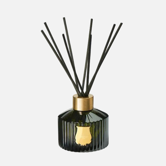 Diffuser with black sticks and gold cap on a white background