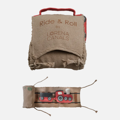 Folded blanket with 'Ride & Roll by Lorena Canals' text and a toy train on a beige background.