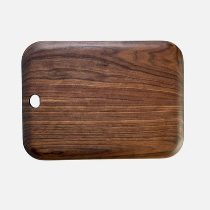 Wooden cutting board with a hole on a marble surface