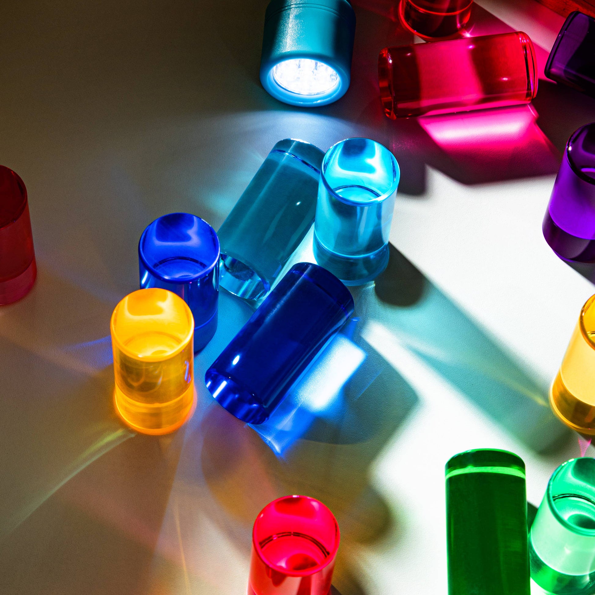 Colorful blocks on a reflective surface with shadows