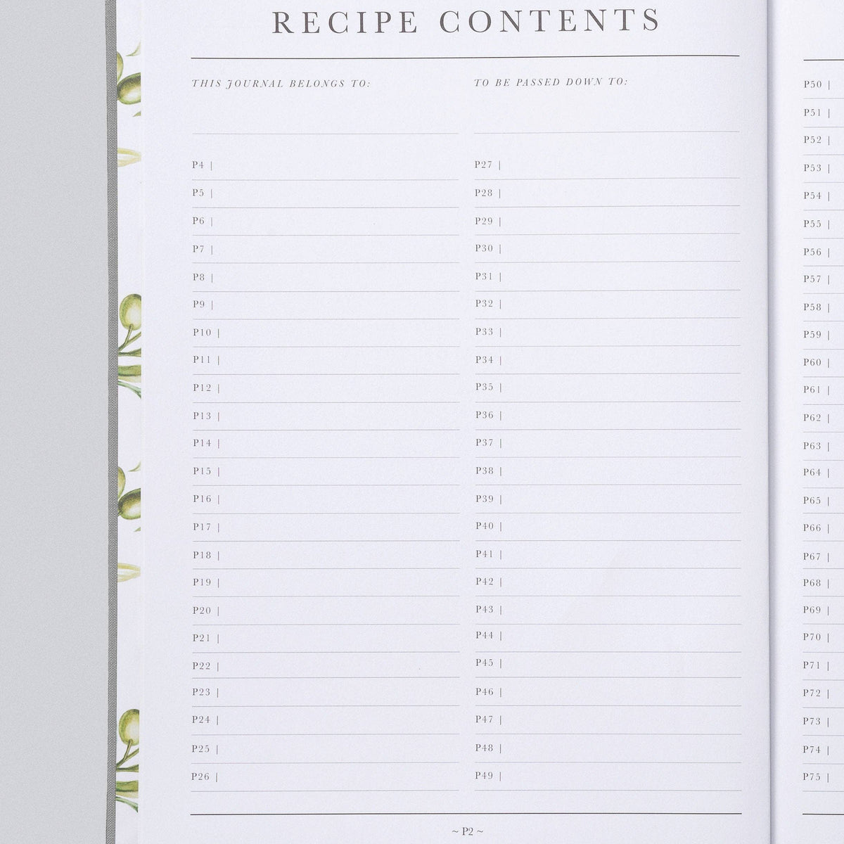 An open recipe journal or planner showing printed recipe contents pages with lined fields and decorative green leaf illustrations along the left margin, photographed on a light gray background.