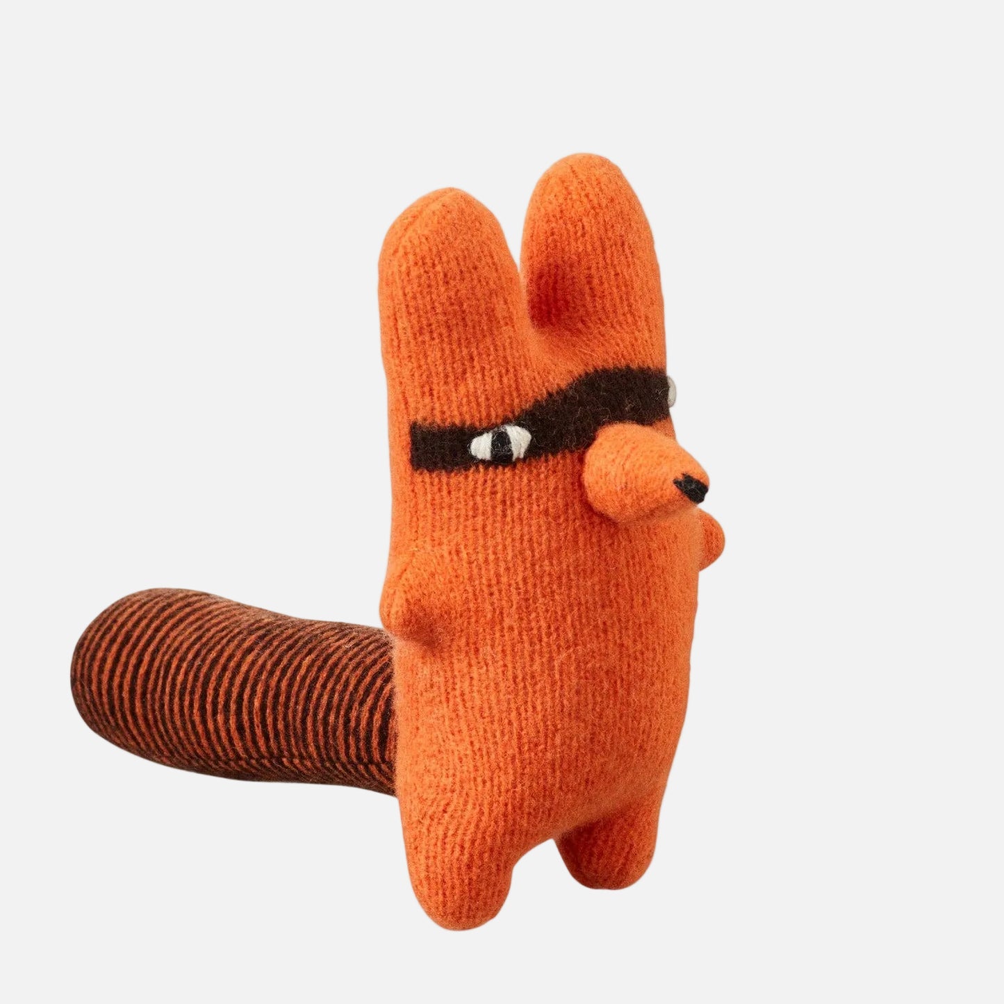 Knitted toy resembling a llama with a brown body and orange head on a white background