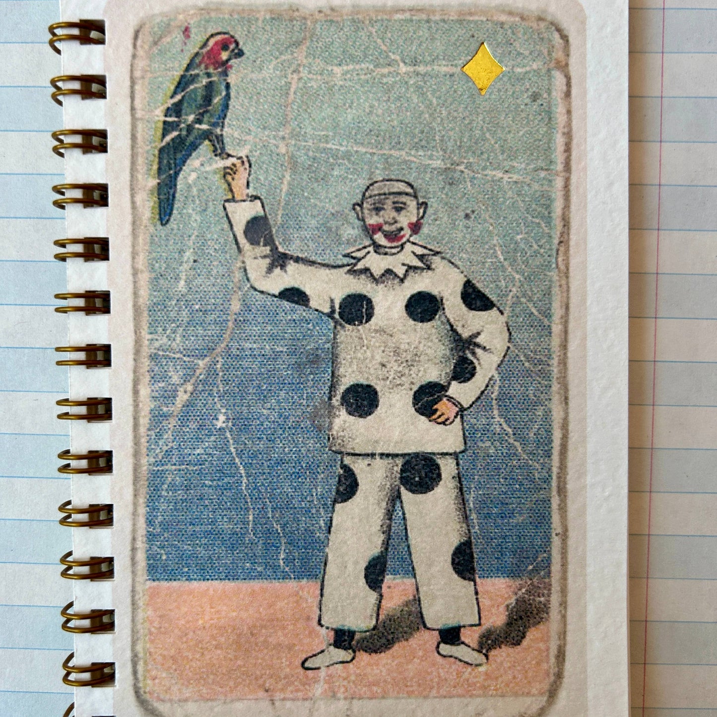 Notebook with a vintage-style illustration of a clown holding a parrot on a tiled floor.