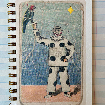 Notebook with a vintage-style illustration of a clown holding a parrot on a tiled floor.