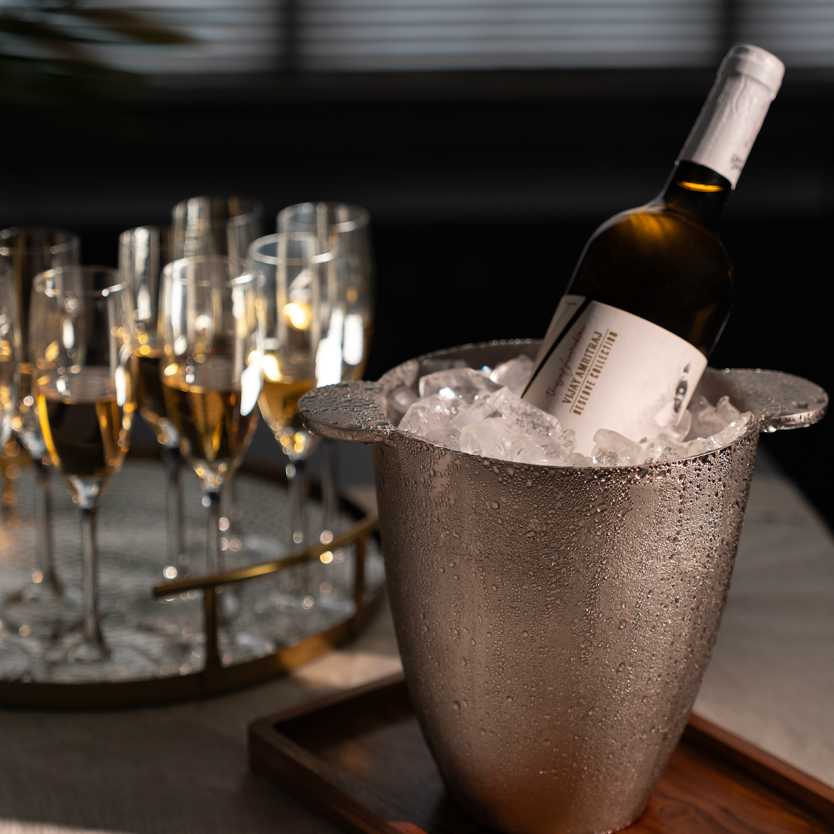 Bottle of white wine in an ice bucket with glasses on a table