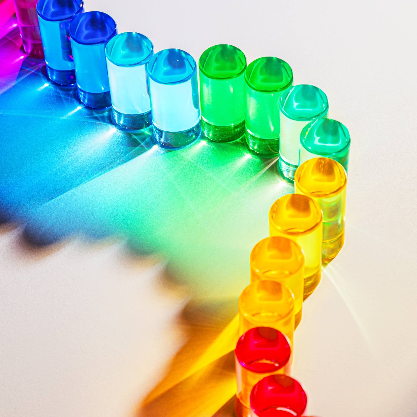 Colorful blocks arranged in a rainbow pattern on a reflective surface.