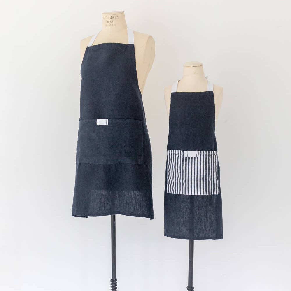 Two denim aprons on mannequins against a white background