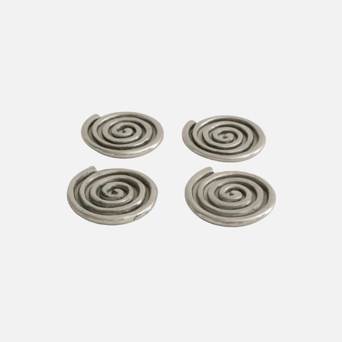 Four silver spiral earrings on a beige background