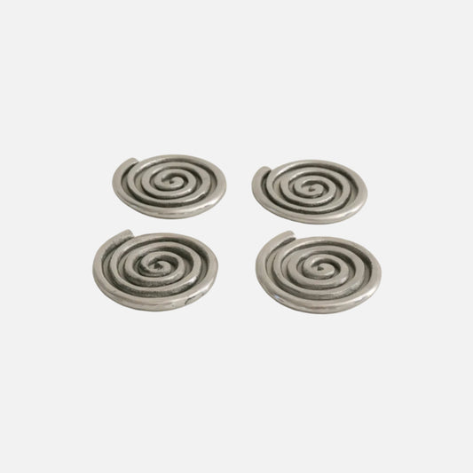 Four silver spiral earrings on a beige background