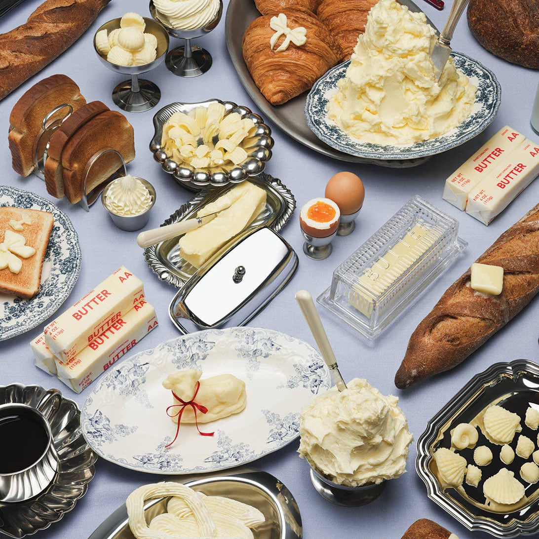 Assorted pastries, bread, and butter on a table with a blue background