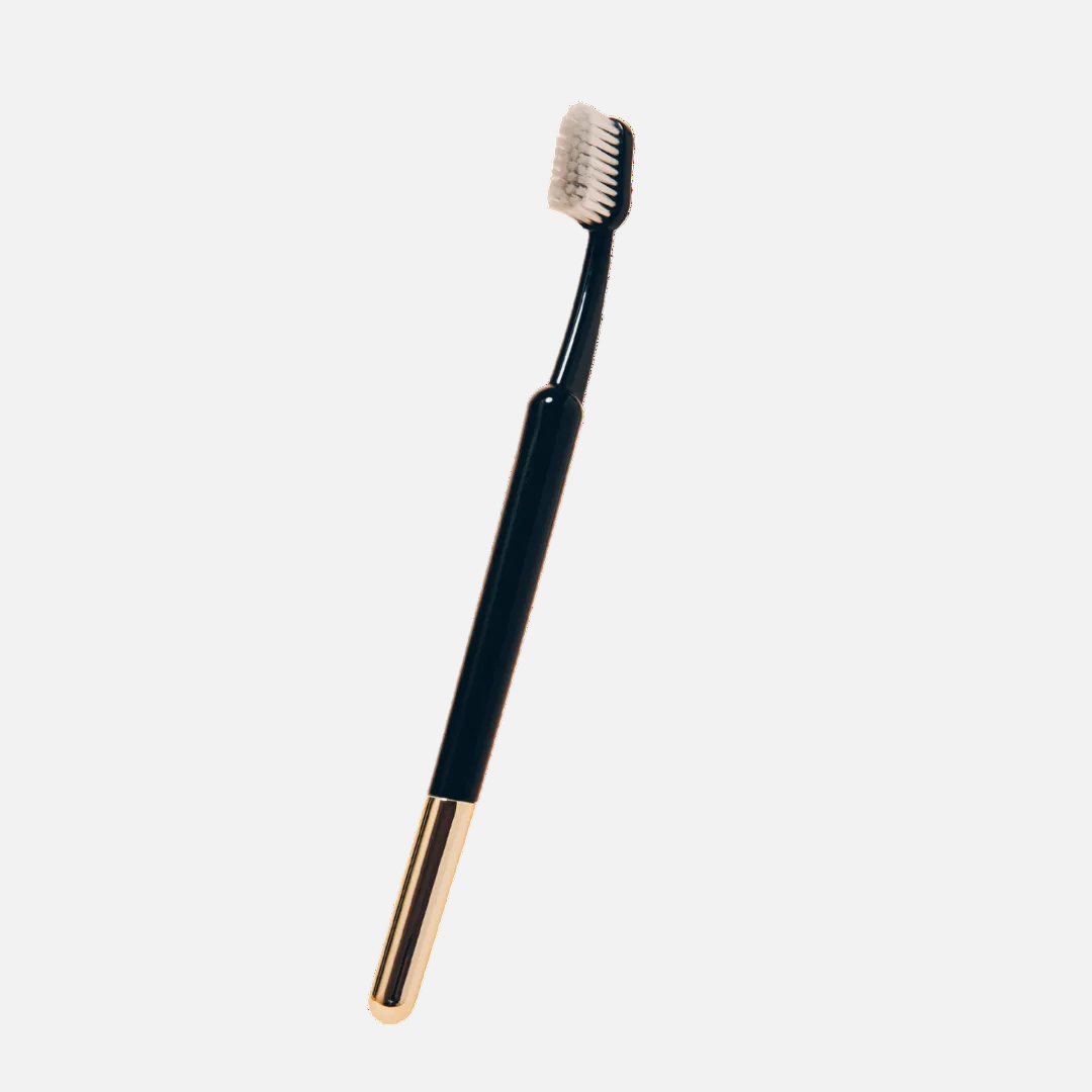 Black and gold toothbrush on a white background