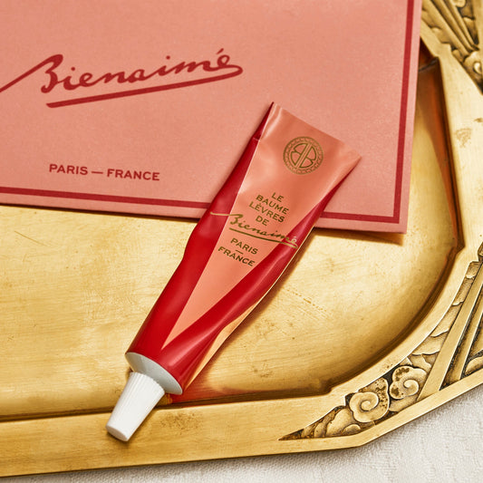 Red tube of cream on a decorative gold tray with 'Bienaime' branding.
