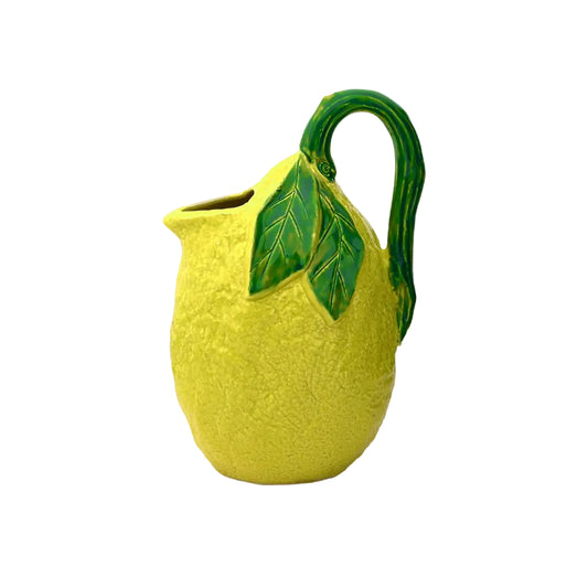 Yellow ceramic pitcher with green leaves on a white background